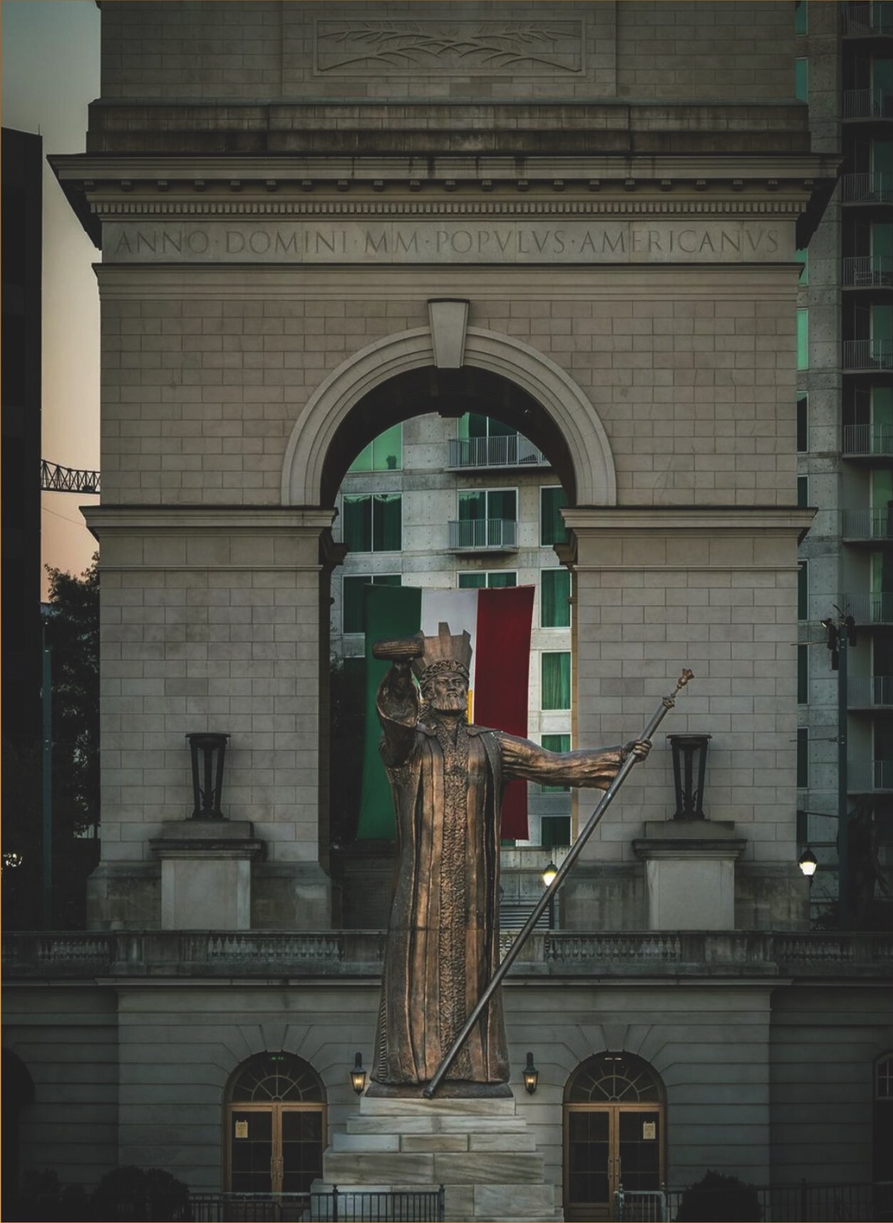 Large bronze civic monument installed before a historic building